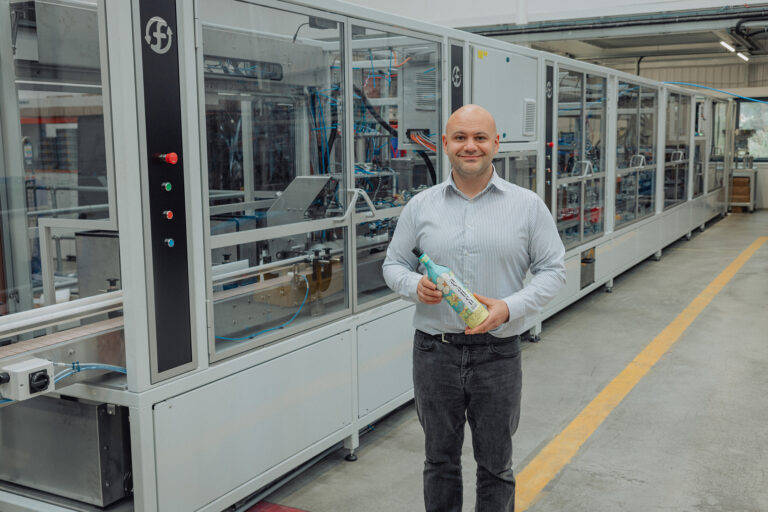 Frugalpac Product Director JP Grogan and the new Frugal Bottle Assembly Machine 2 (FBAM-2)